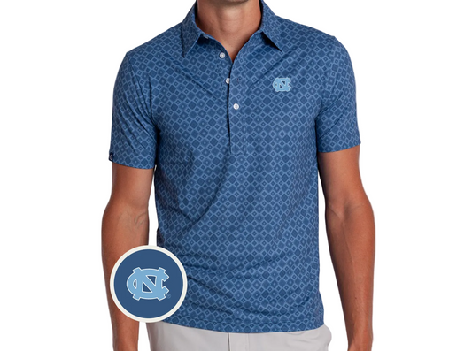 A man wearing a blue short-sleeve polo shirt with a repeating geometric pattern and a light blue UNC logo on the left chest. A circular inset shows the UNC logo detail.
